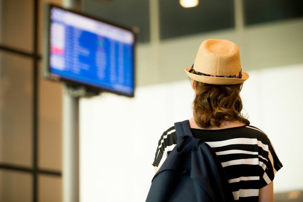 uma pessoa olhando o telão do aeroporto 