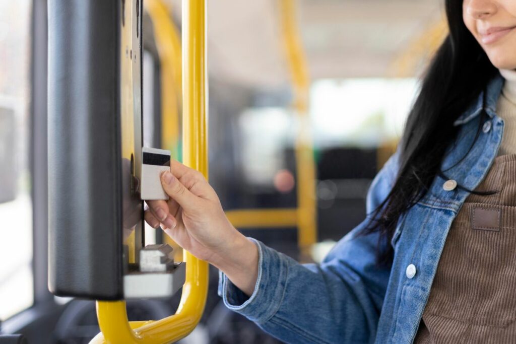 mulher passando o cartão de passagem no ônibus