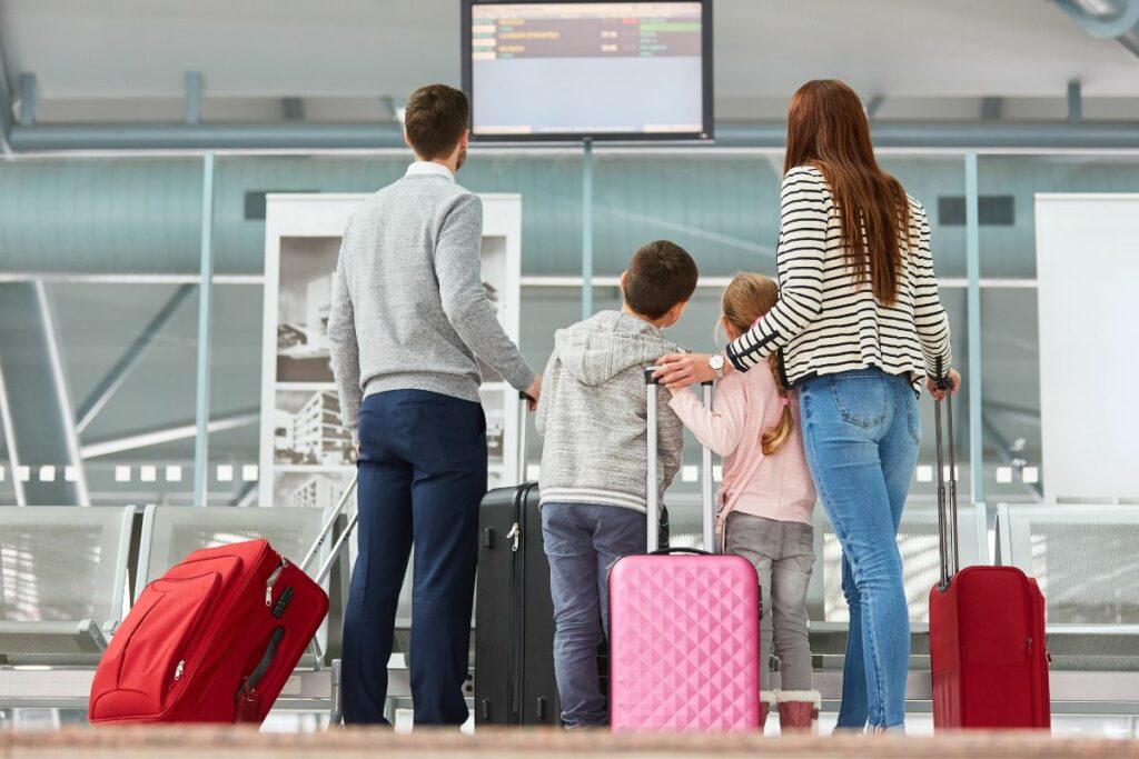 Família esperando com bagagens no aeroporto